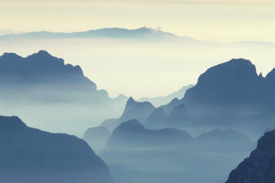 Foggy mountain landscape with layered peaks and mist.