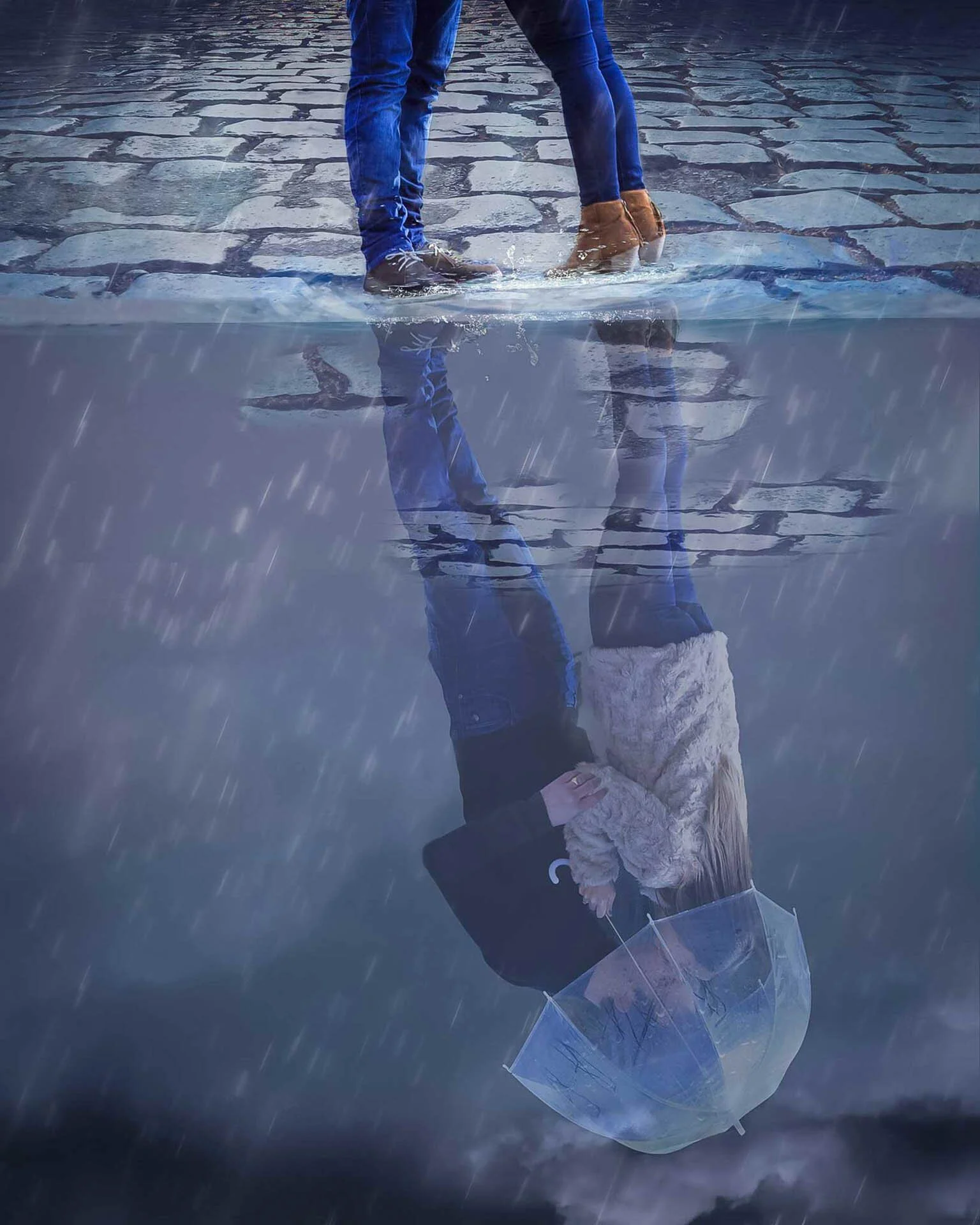 Couple standing on wet cobblestone street with their reflection in a puddle, holding an umbrella, while rain falls.