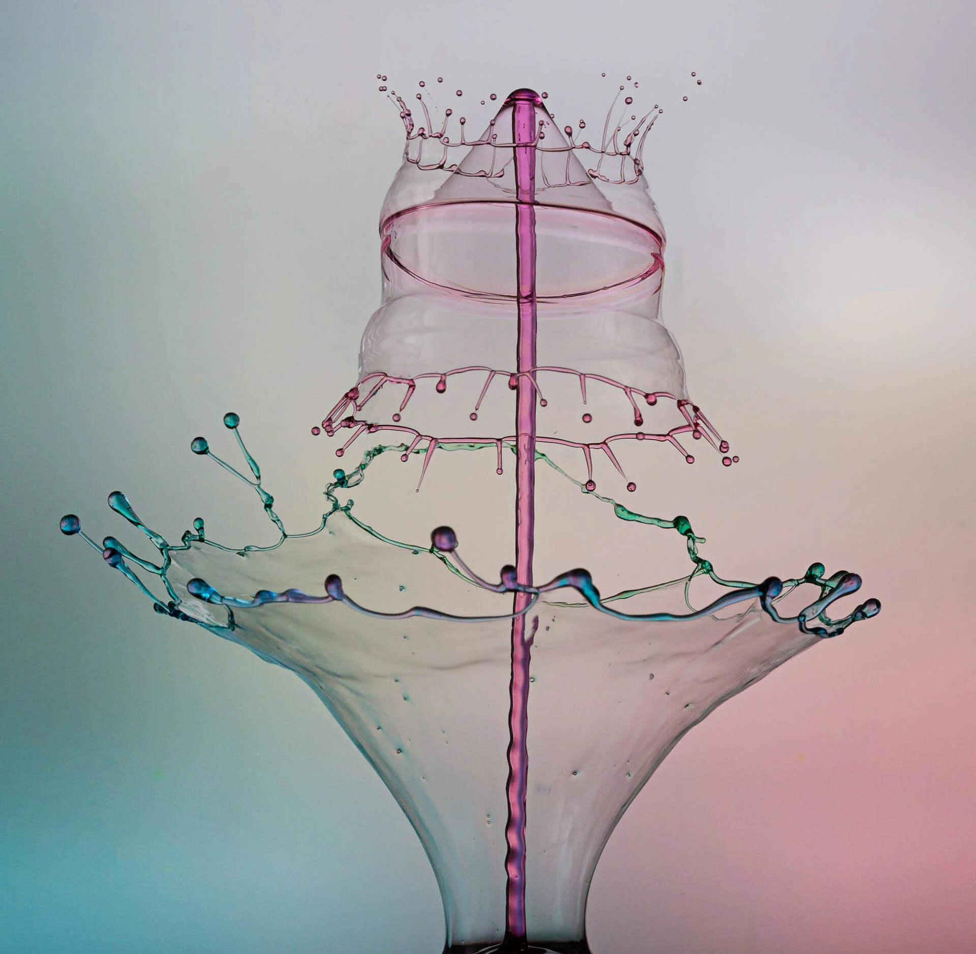 High-speed photography of a colorful liquid splash creating a crown-like shape, with intricate droplets and reflections.