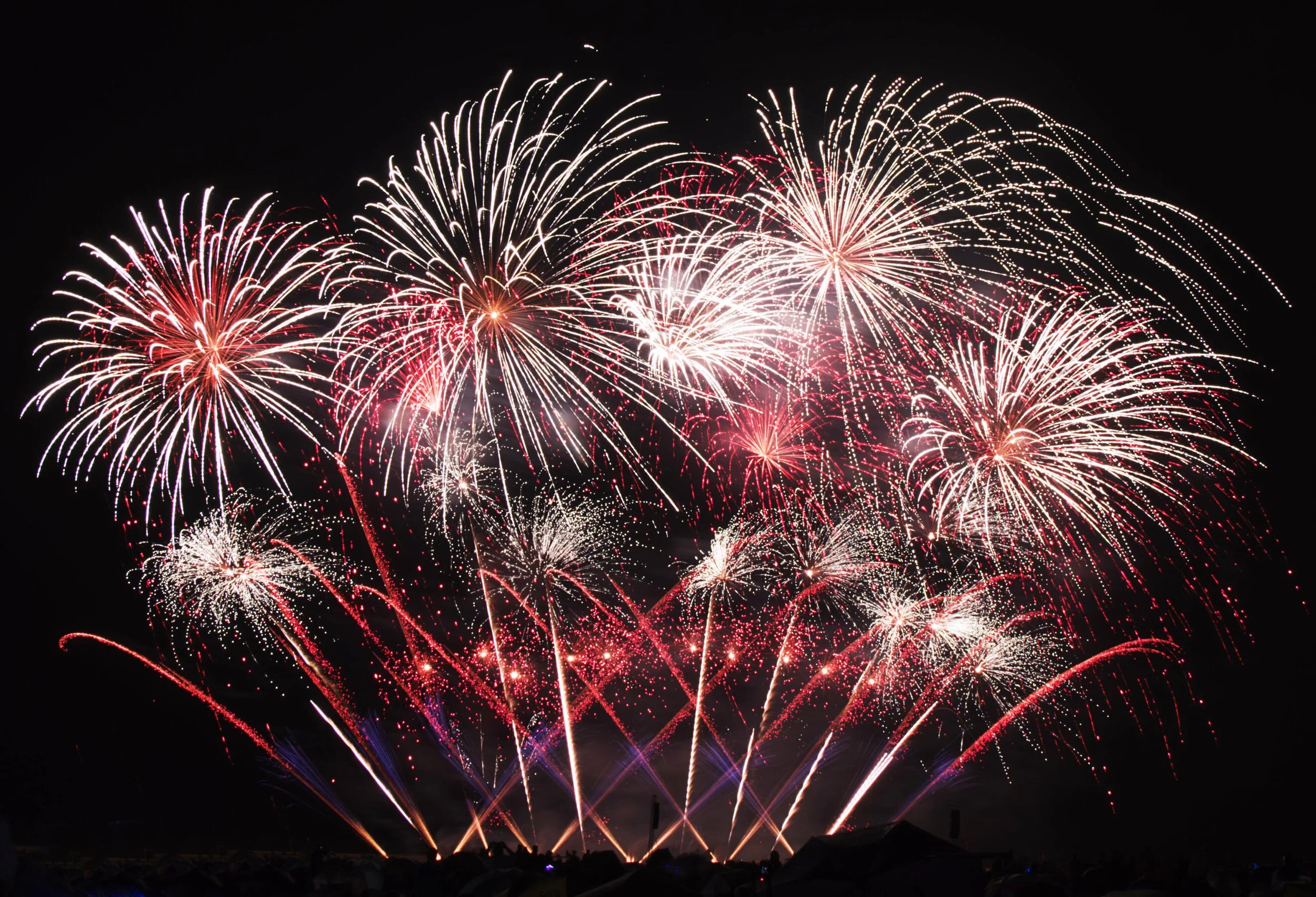 Colorful fireworks display in the night sky with red, white, and blue bursts.