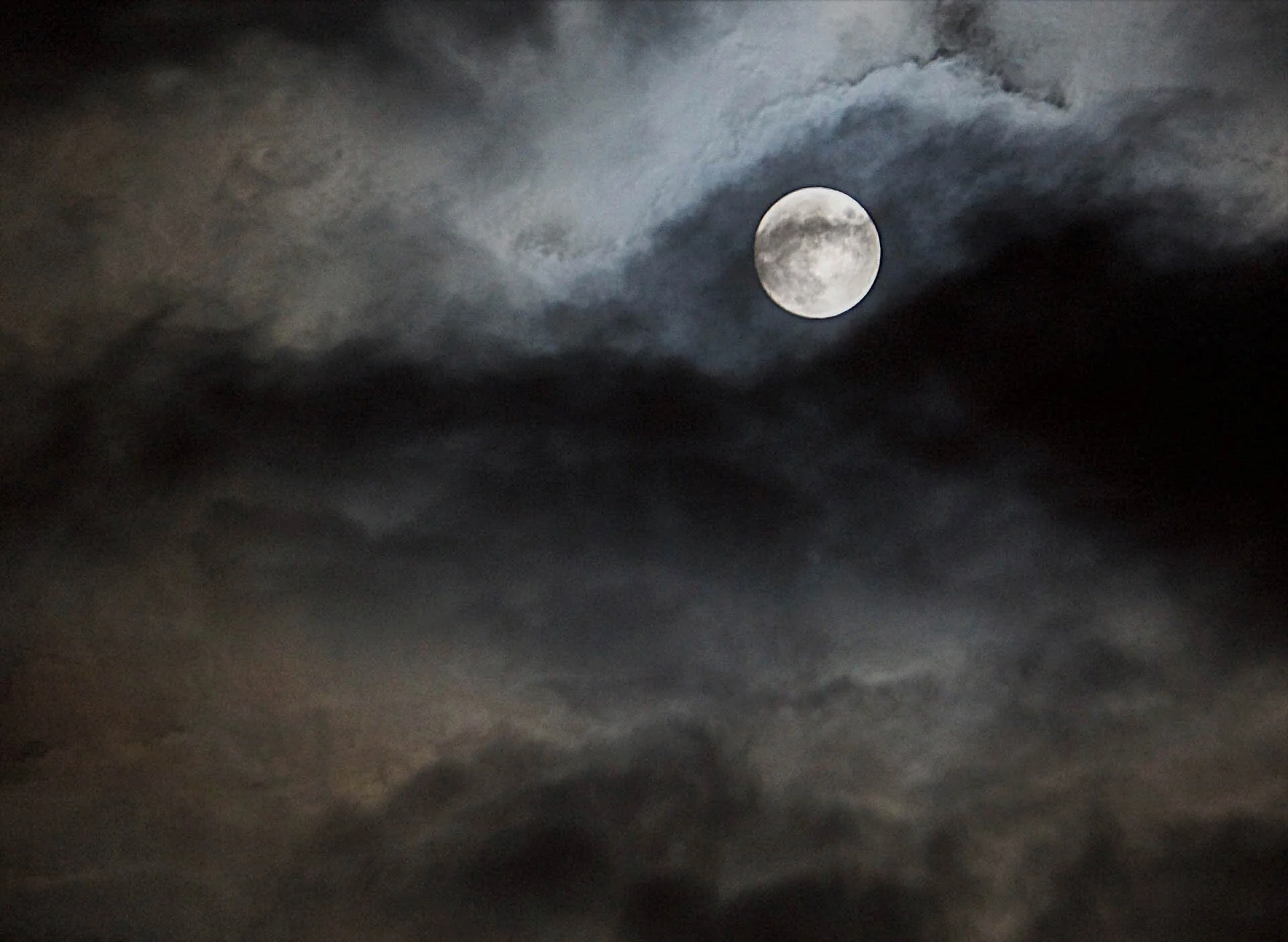 Full moon in a cloudy night sky