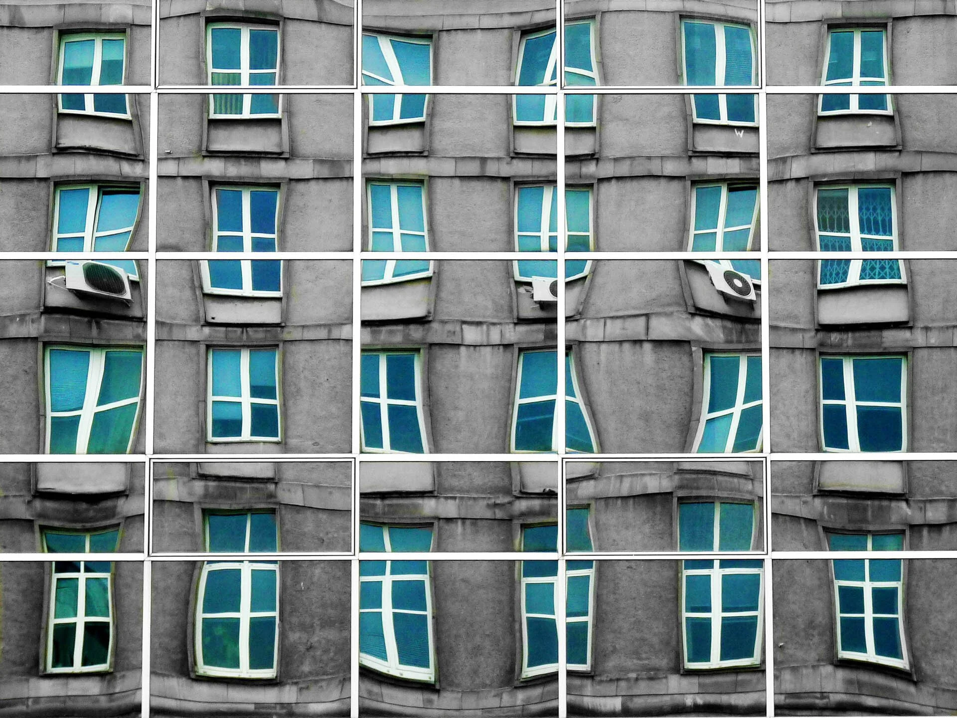 Distorted facade of a building with green-tinted windows