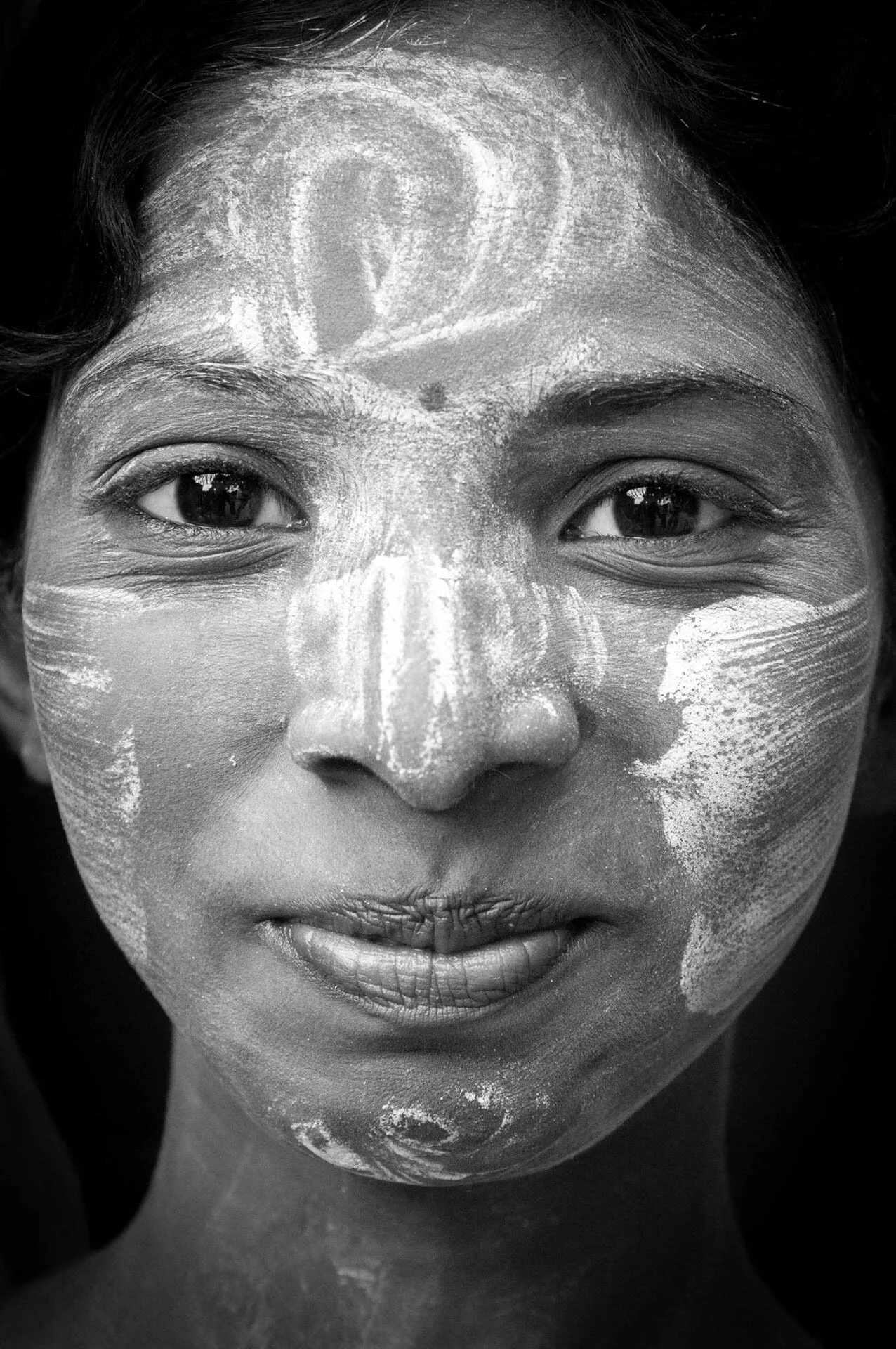 Close-up of a face with traditional white paint designs