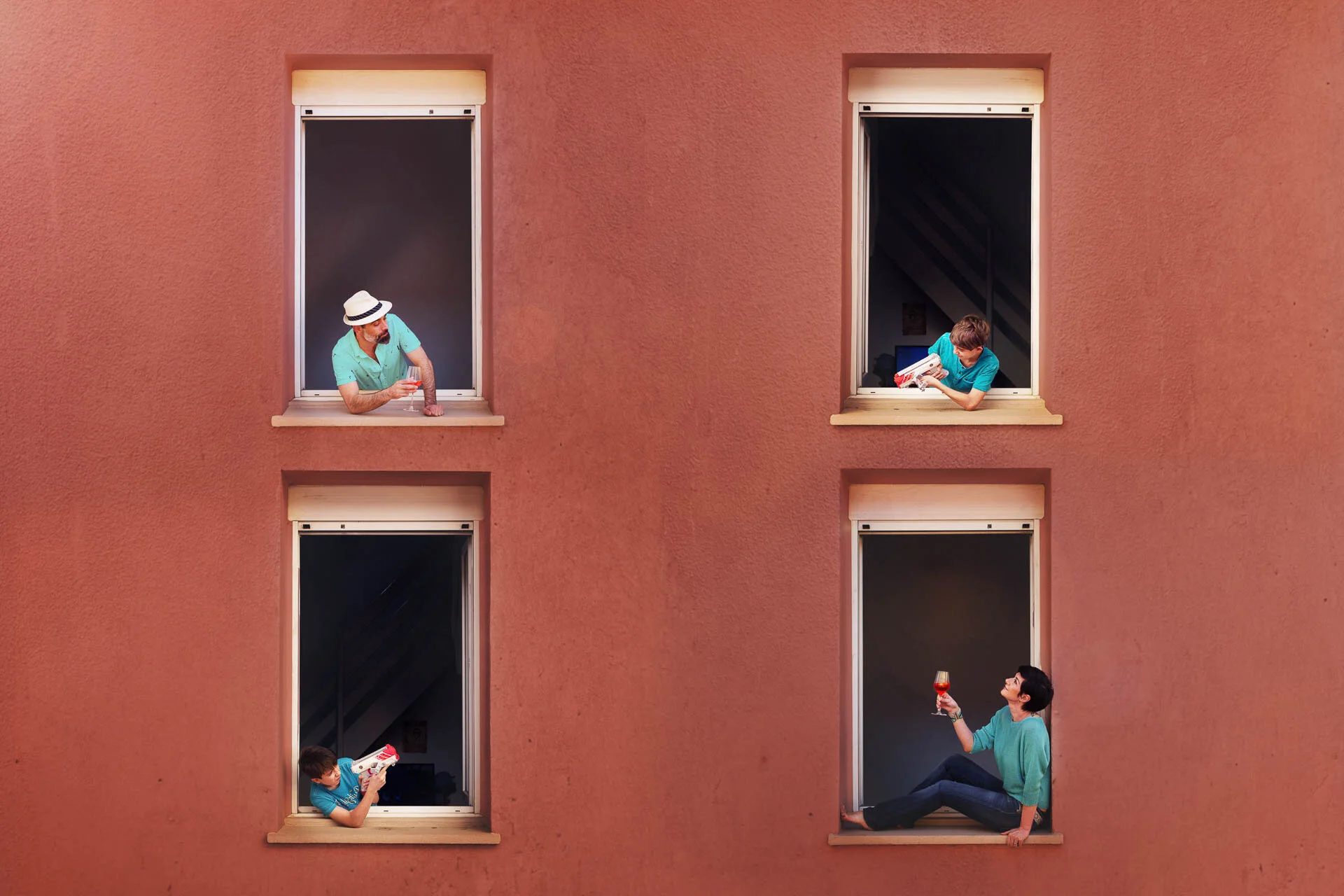 Four people each sitting in their own window on a red wall, engaged in various activities such as reading and holding drinks.