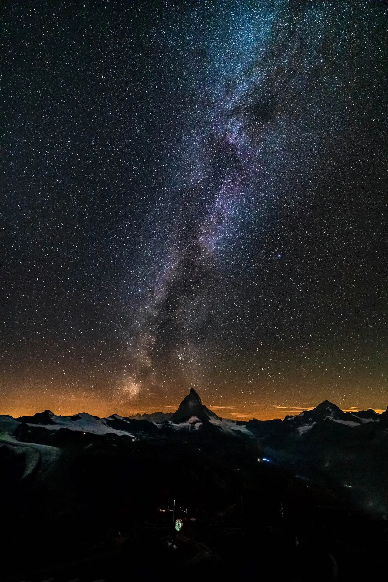 Night sky with the Milky Way over a silhouette of mountains.