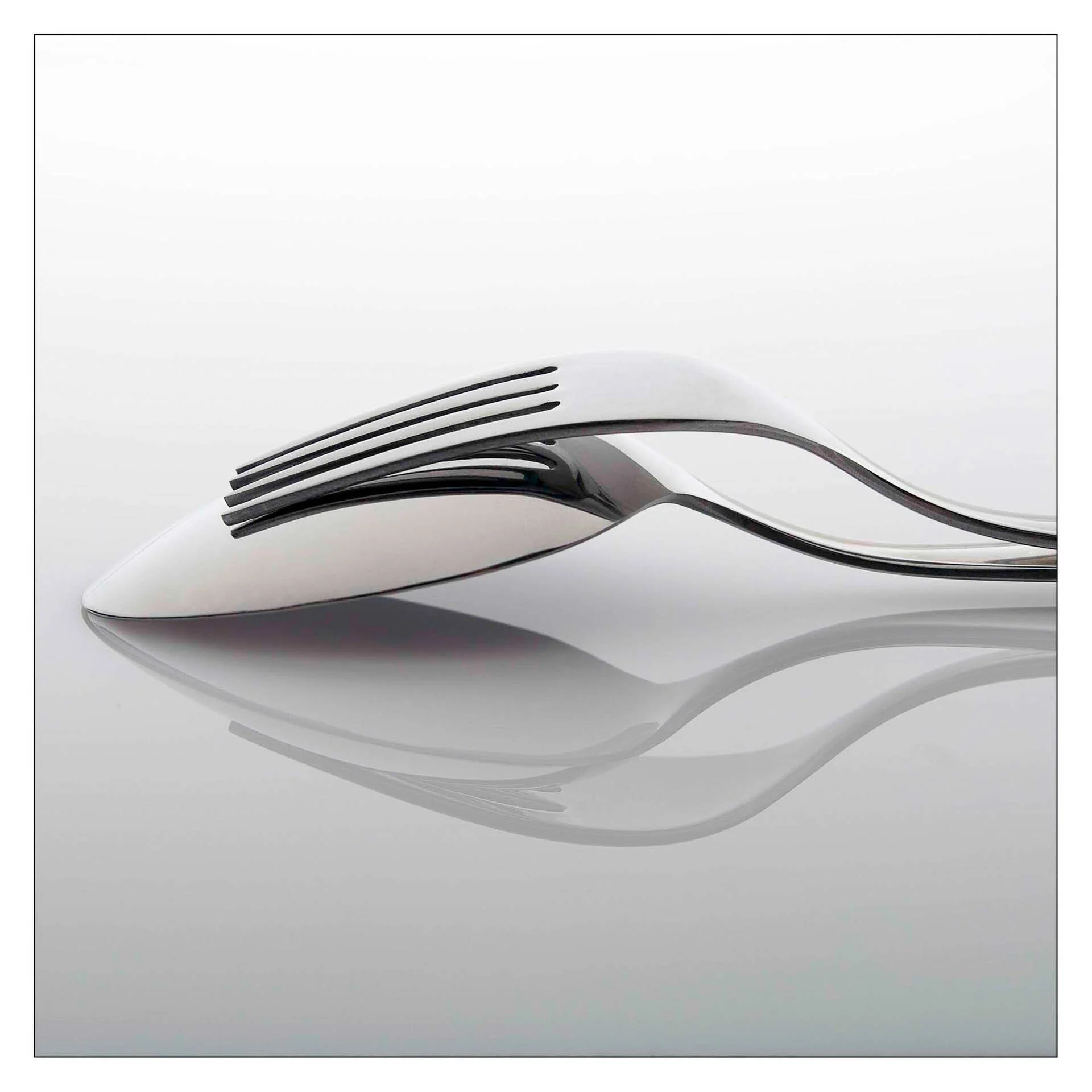 Reflection of a fork and spoon on a glossy surface in a minimalist style.