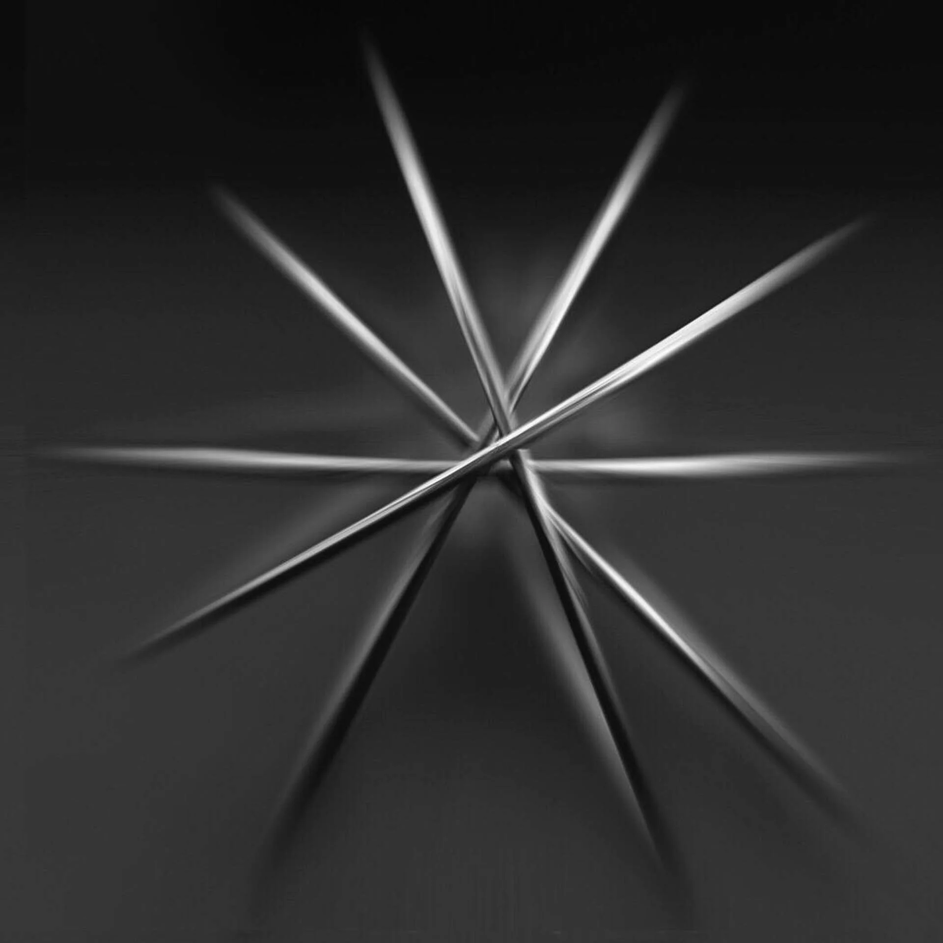 Abstract arrangement of metal skewers forming a star shape, black and white.
