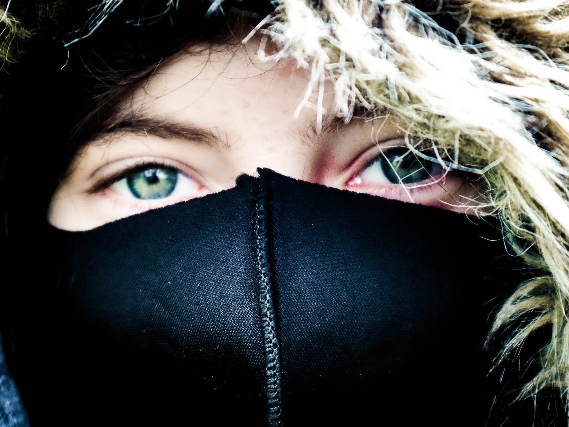 Close-up of eyes with a hood and face covering