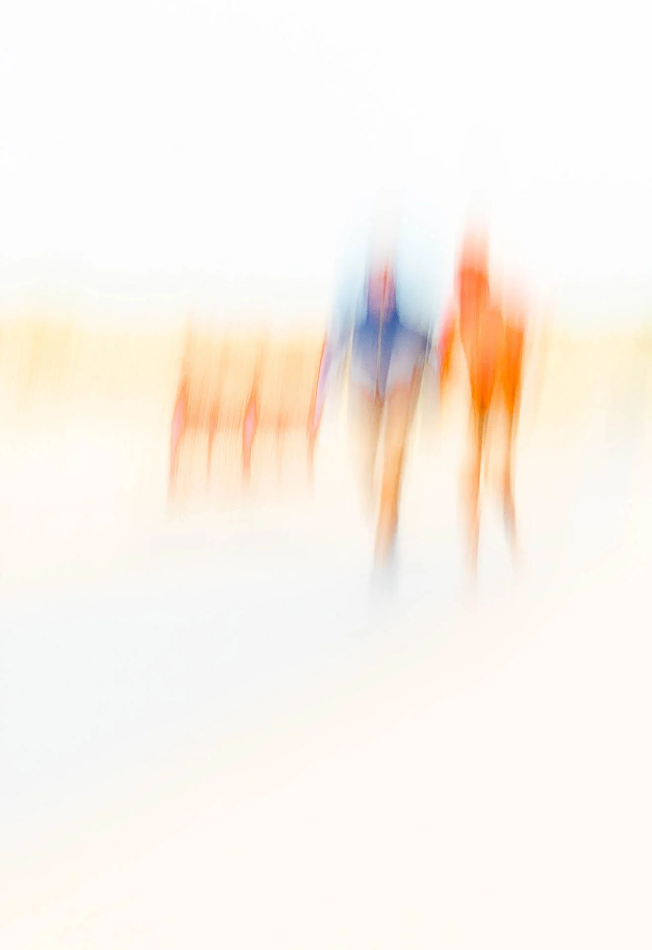 Abstract image of two blurred figures on a beach with warm colors.