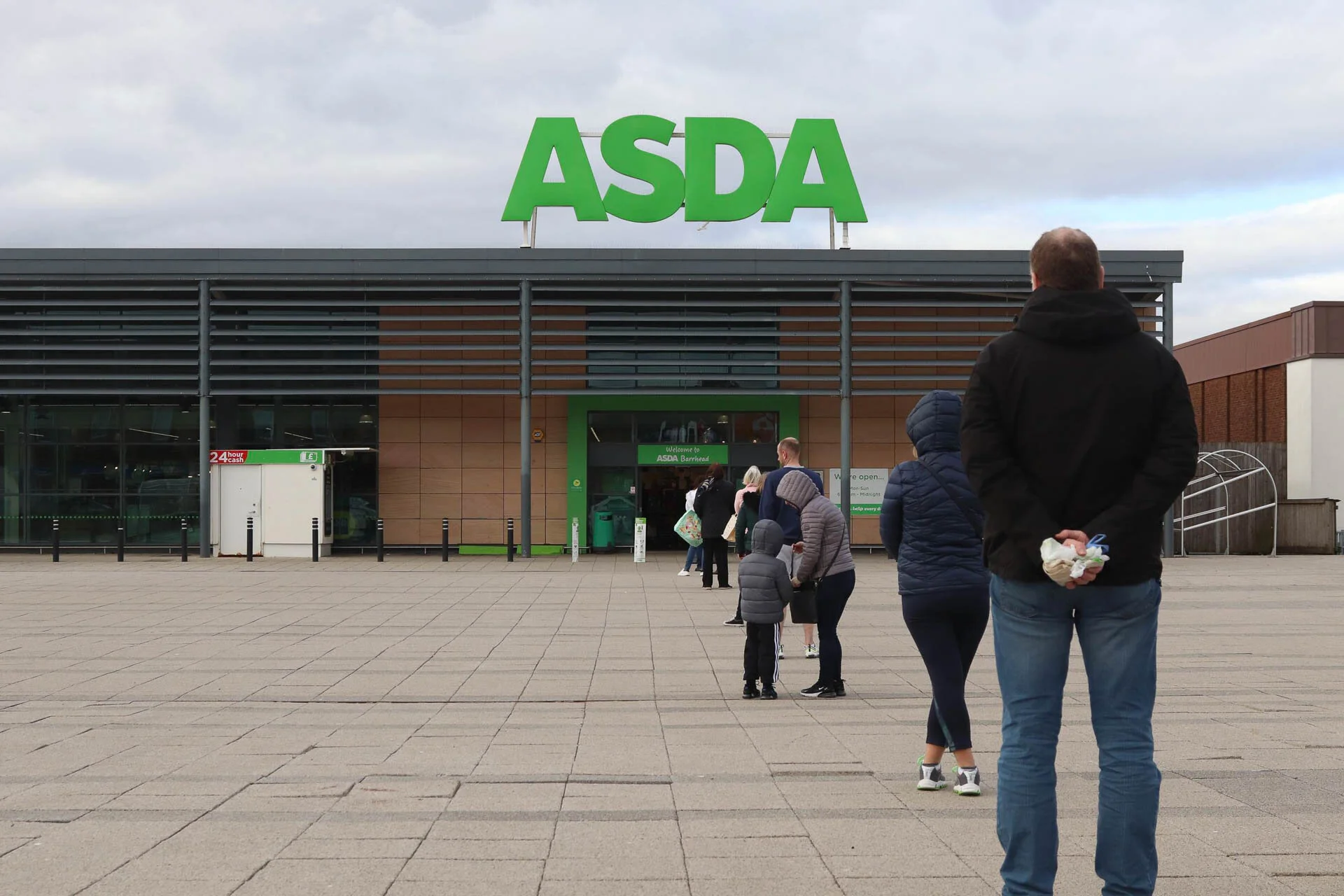 People in line outside an ASDA store with social distancing measures.