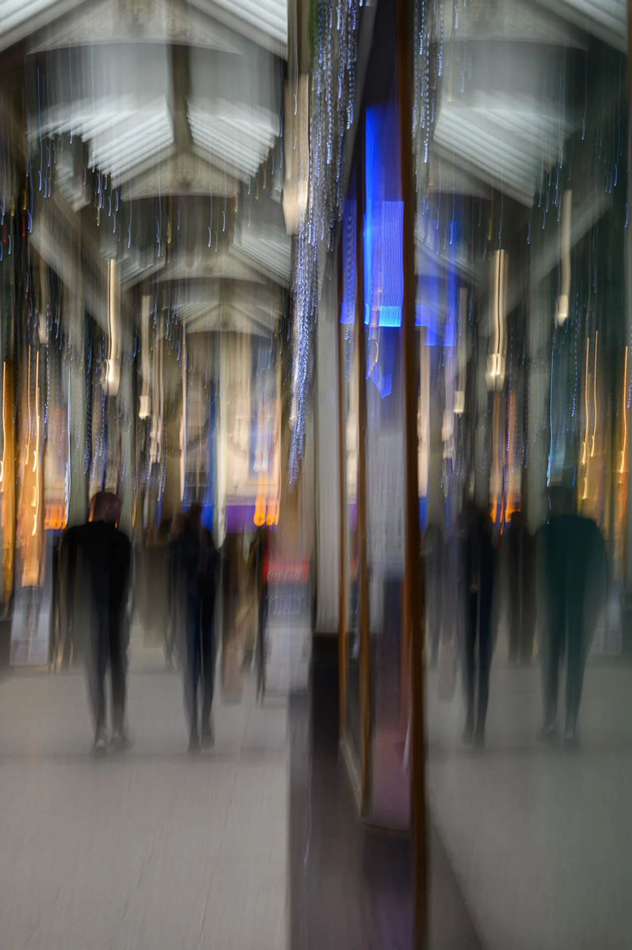 Blurred image of a shopping arcade with reflections and bright lights.