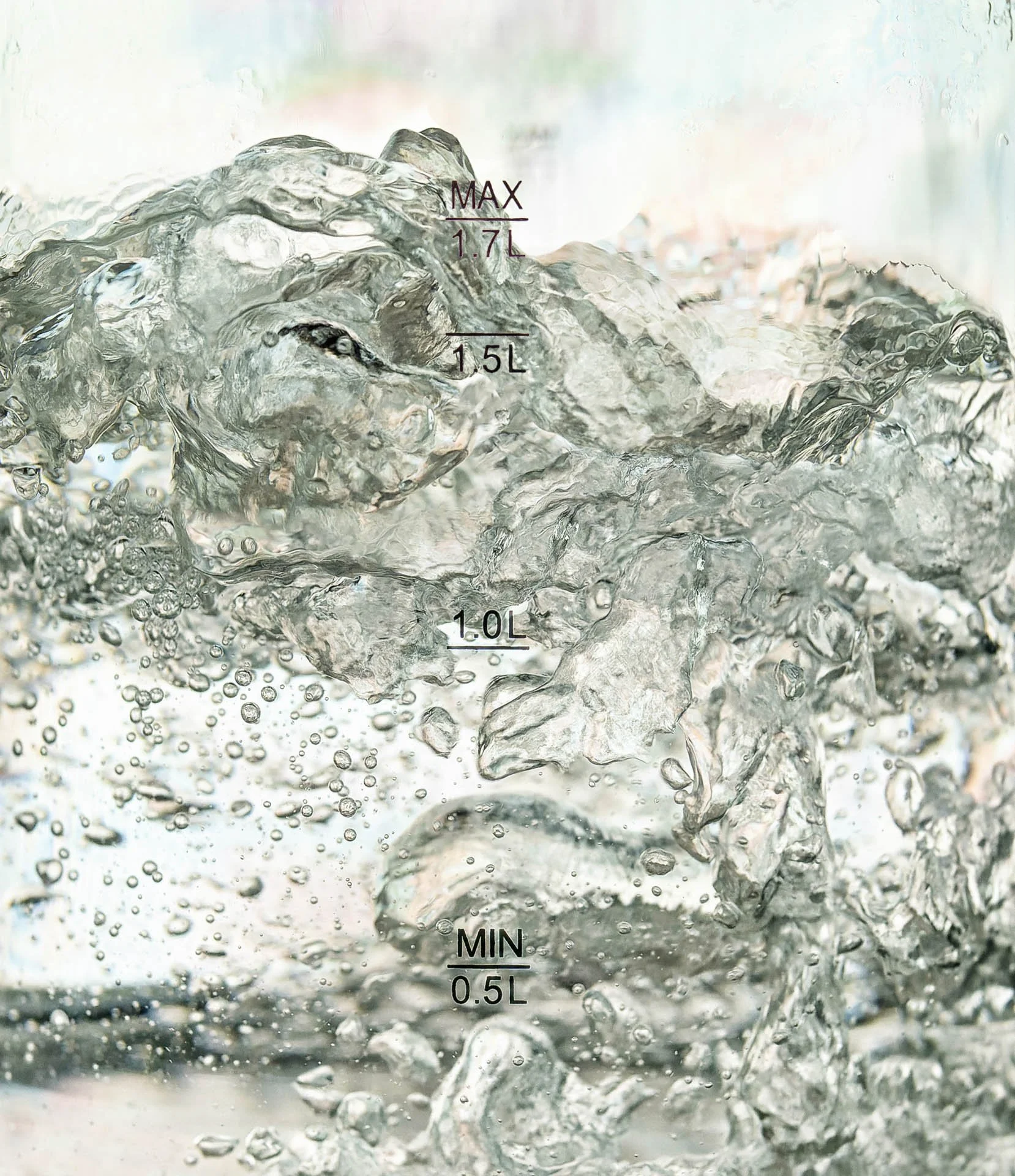 Water boiling in a glass container with volume markers 0.5L, 1.0L, 1.5L, and 1.7L.